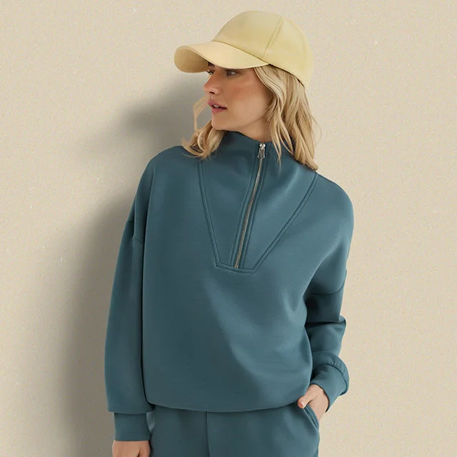 Woman in teal sweatshirt and yellow cap