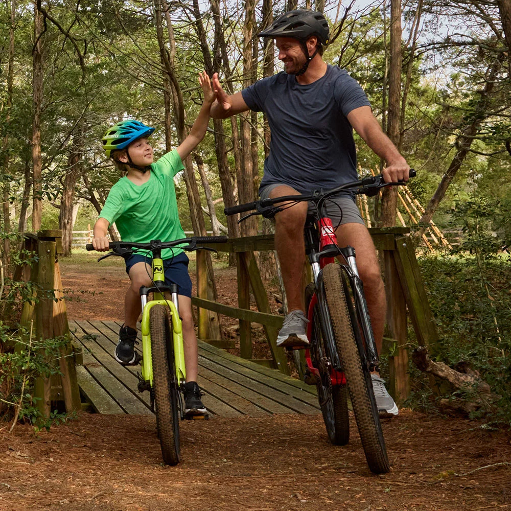 Father and son high-five while cycling outdoors