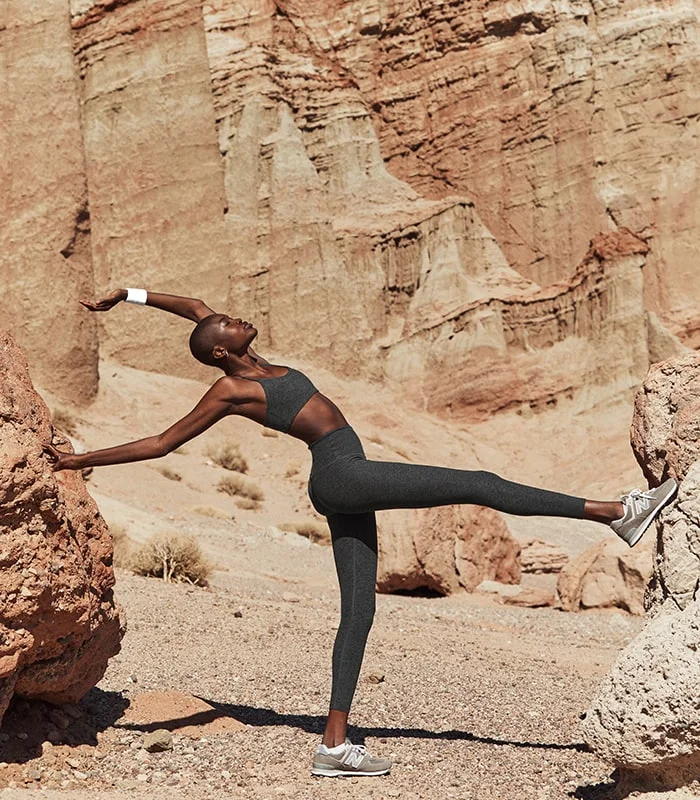 Woman stretching in a canyon.