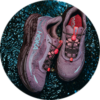 Purple Hoka running shoes on wet ground