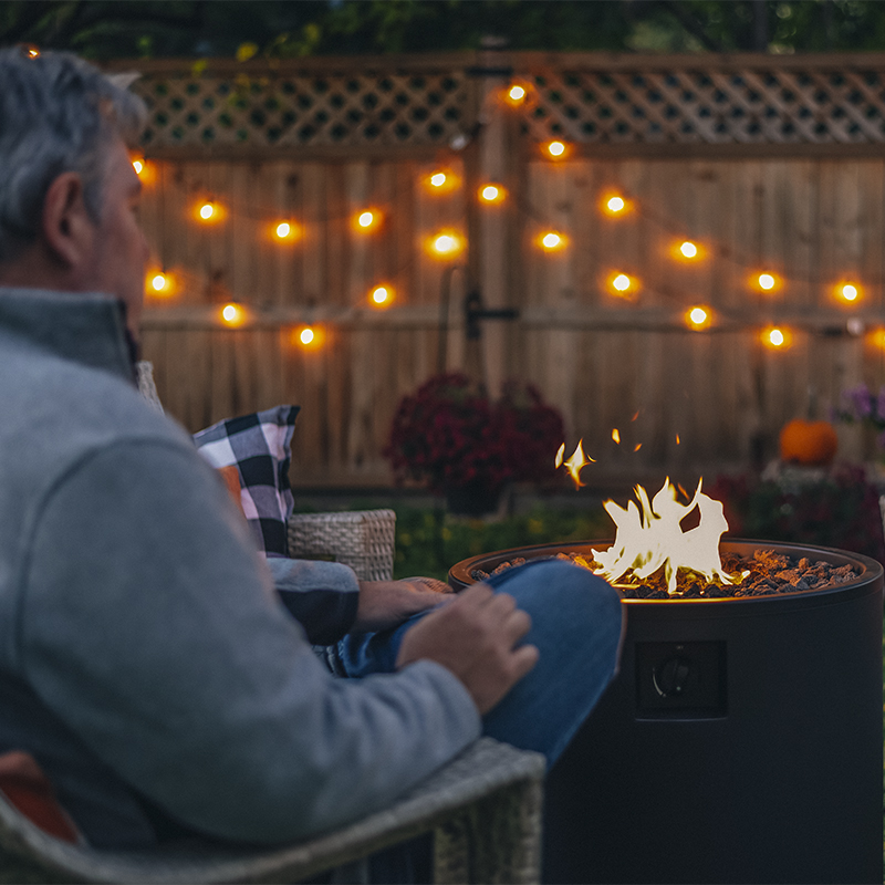 Man relaxing in the backyard by a fire