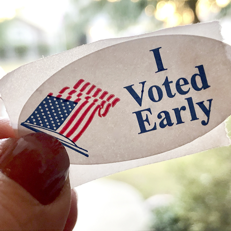 I voted early sticker on a middle aged woman’s finger