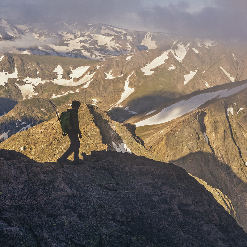 A hiker hikes a ridge along the Trough, Keyhole Route, Longs Peak, Rocky Mountain National, Park. Colorado.