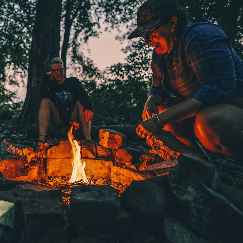 Two women prepare a fire on Sycamore Island