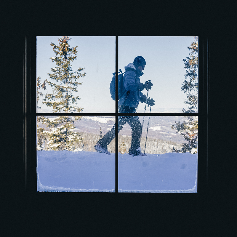 A view out a window of a alpine touring skier