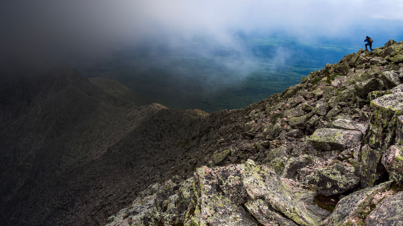 A hiker on the knifes edge of Mount Katahdin in Katahdin Woods and Waters 