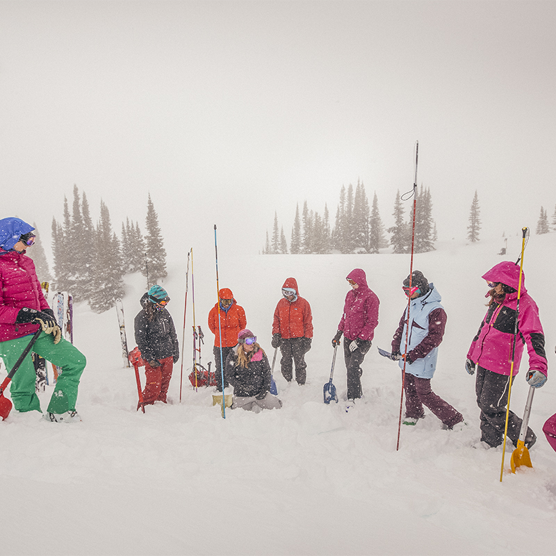 Woman skiers practicing avalanche shovel and digging skills in Albert Canyon in the Selkirk mountains of British Columbia, Canada.