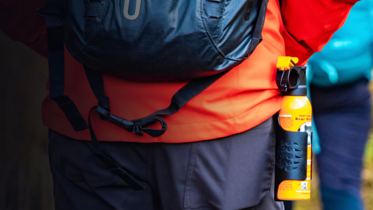 Bear spray self-defence attached to backpackers when hiking 