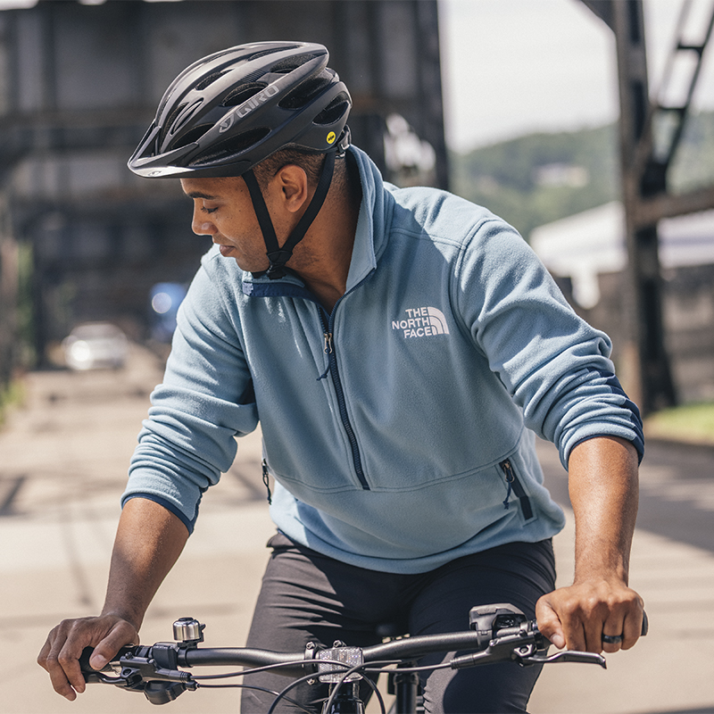 A man looks to the side as he cycles