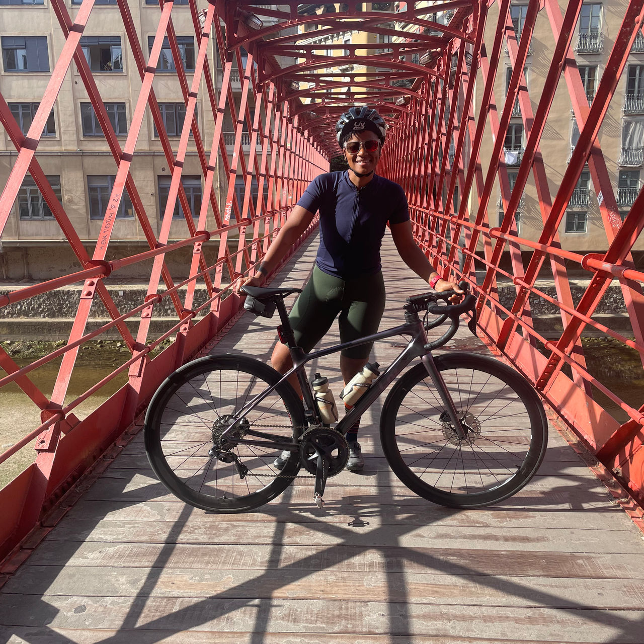 Shequaya Bailey poses for a portrait with her bike on a bridge
