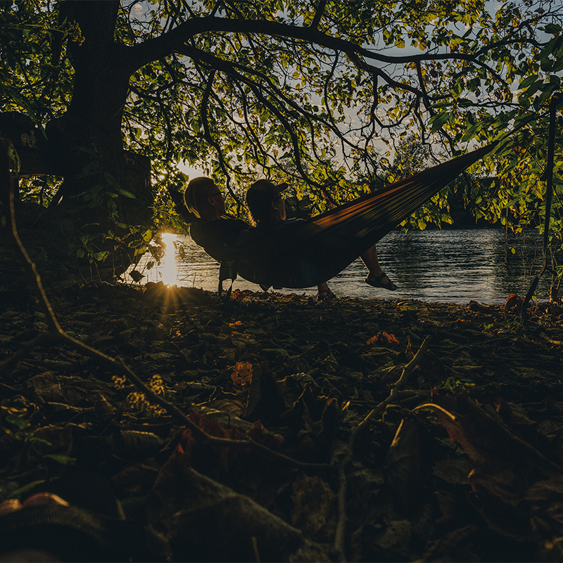 Two women sit on their hammock on Sycamore Island