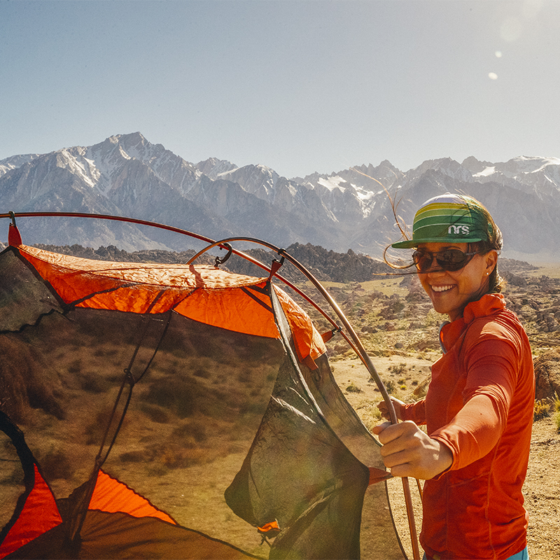 A woman sets up a tent while camping during a windy spring day at the Alabama Hills near Lone Pine, California.