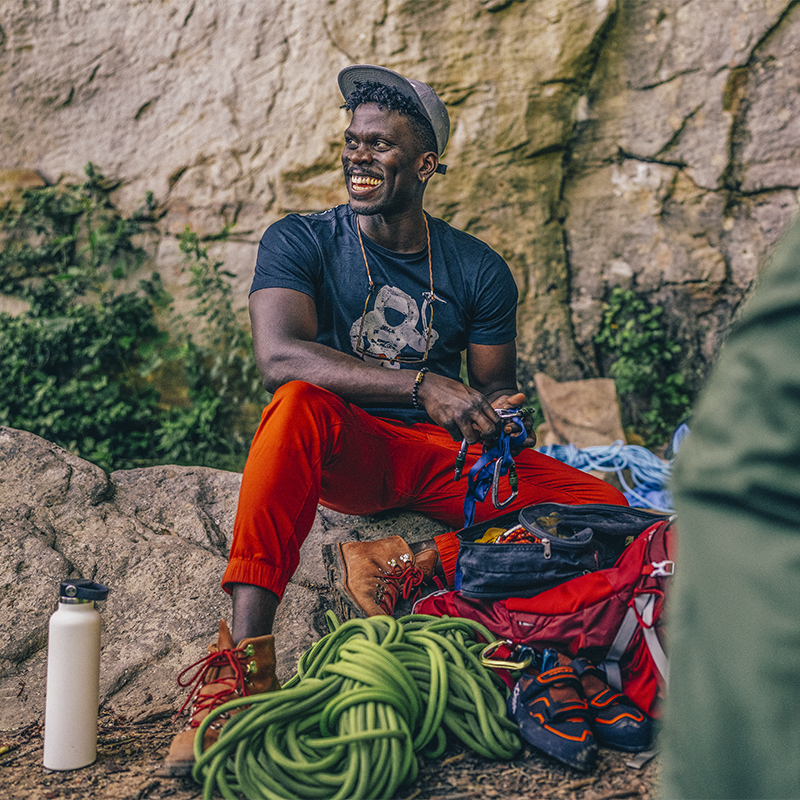 A man sits among climbing rope and gear after climbing