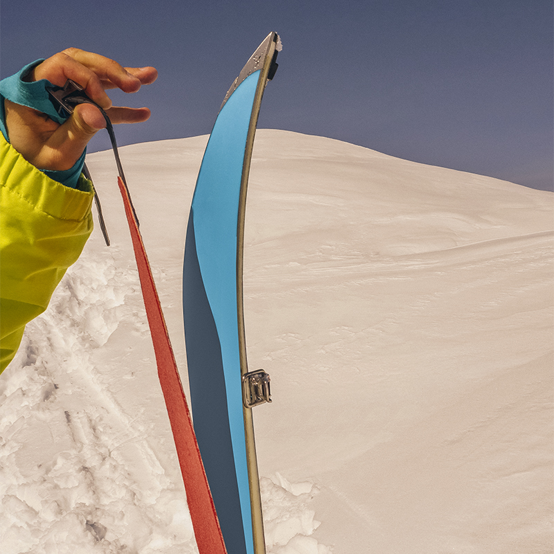 Person sticking climbing skins on split board. Ski touring equipment