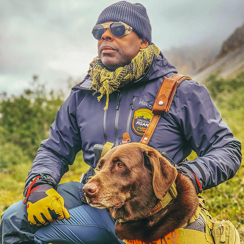 Chad Brown looks on at Arctic National Wildlife Refuge with his dog