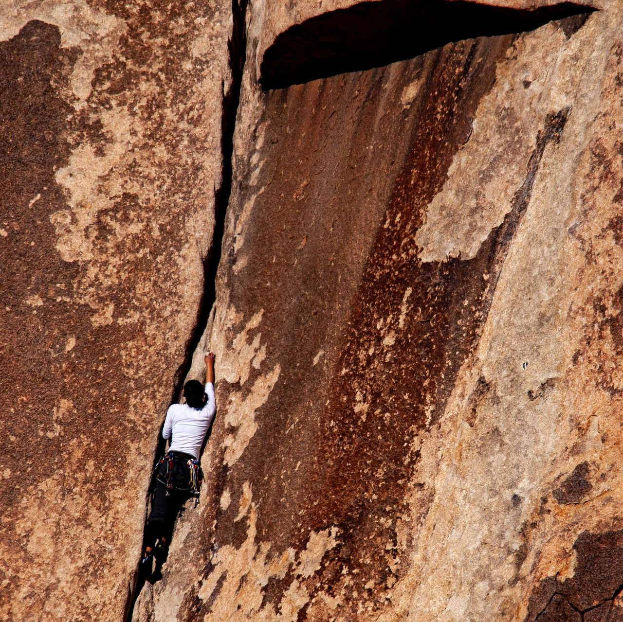 A crack climber climbs the rock