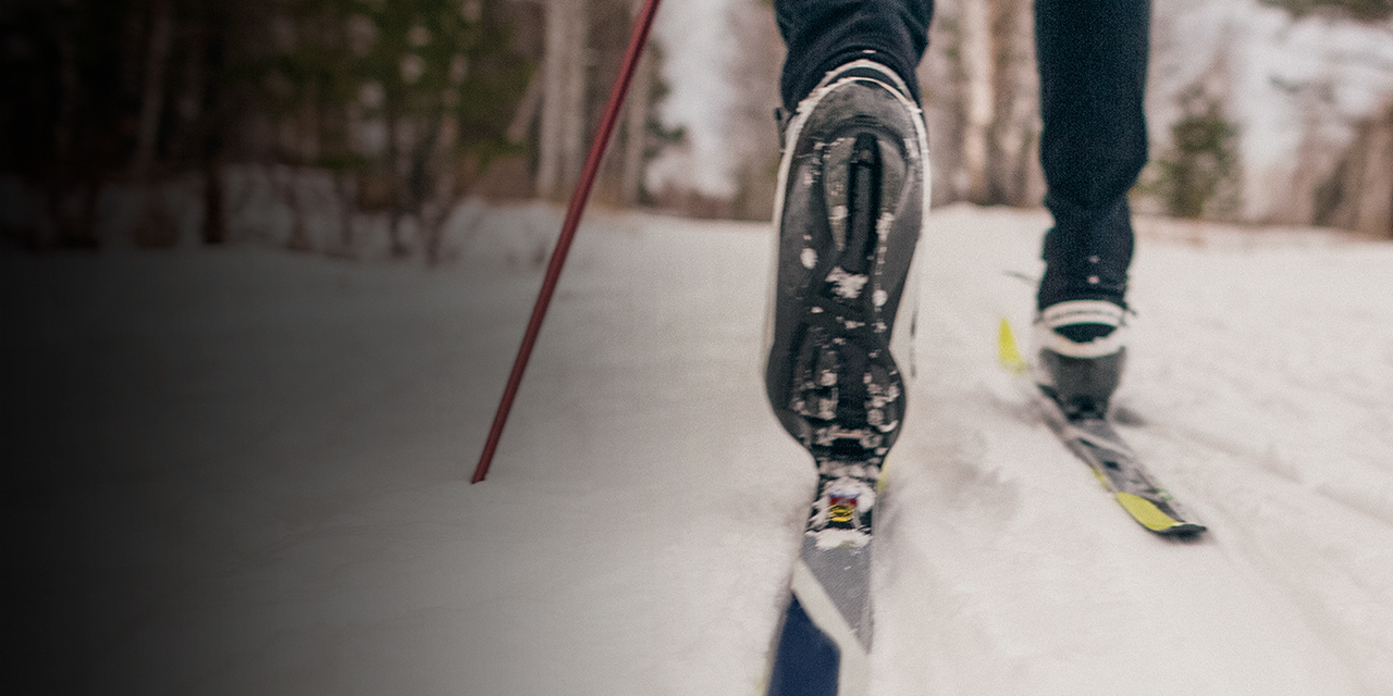 A close up of a cross country skiier boot and ski
