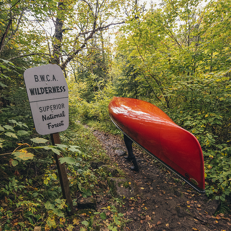 A person carrying a canoe in the boundary waters