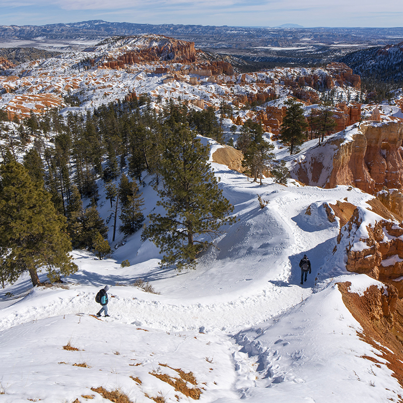 People walk on the trail in the snow at Bryce Canyon National Park