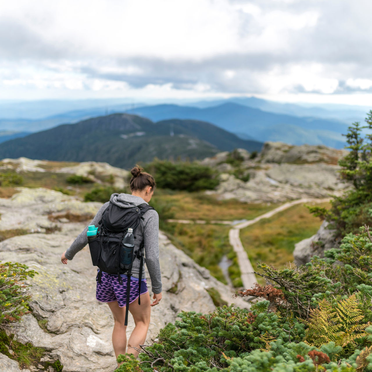 A female hiker finds her footing hiking along Mount Mansfield in Vermont