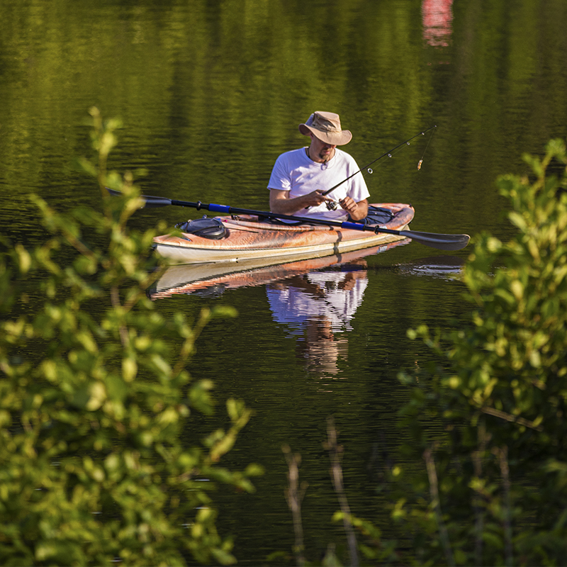 A man fishes from a kayak in North Park Lake