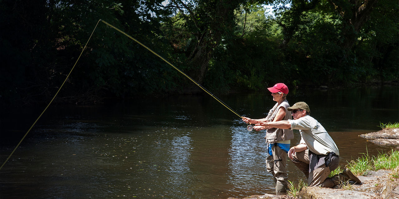 A man and a woman fishing in a river