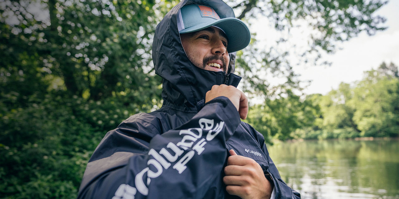 A man zips up his fishing jacket