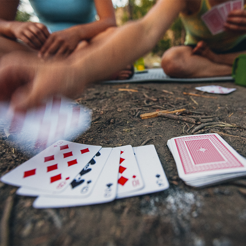 Two women play cards and enjoy a fire while car camping along the Salmon River near Stanley. Idaho.