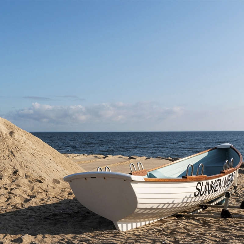 White wooden lifeguard stand and rowboat on the beach at Sunken Meadow State Park, New York