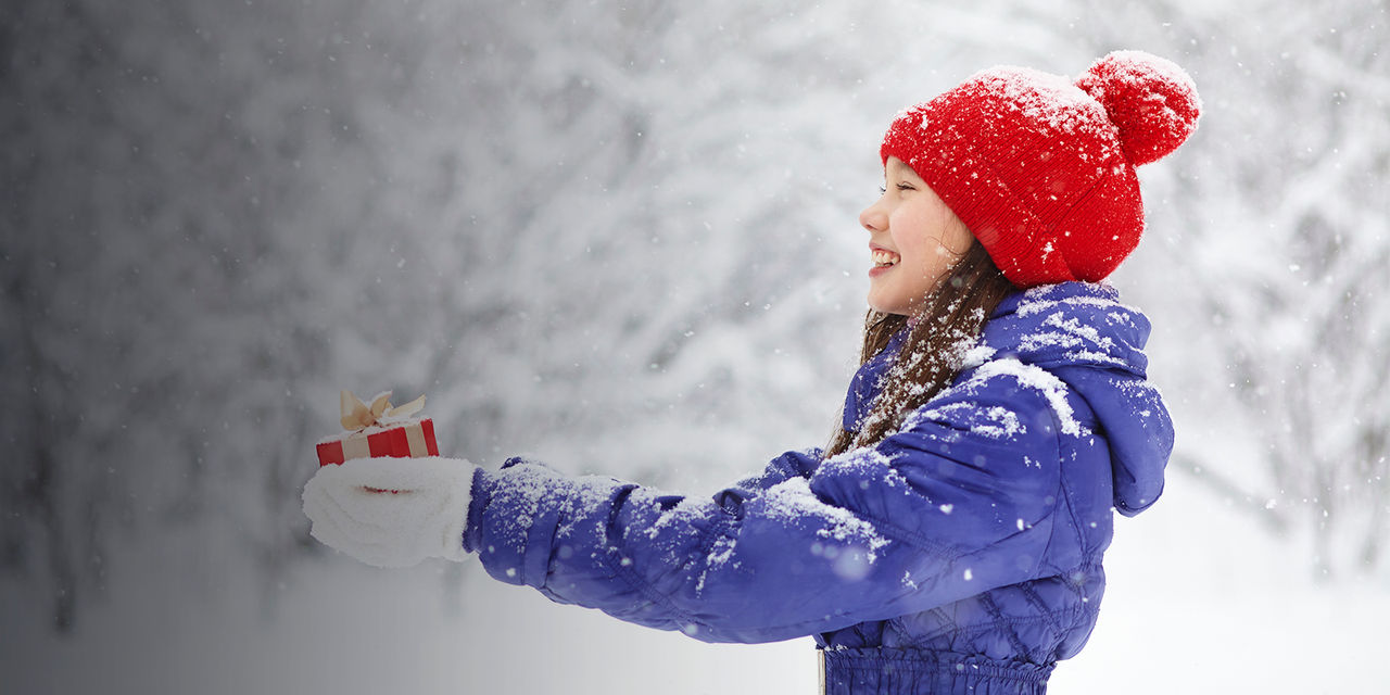 teenage girl in the snow with a gift in her hand