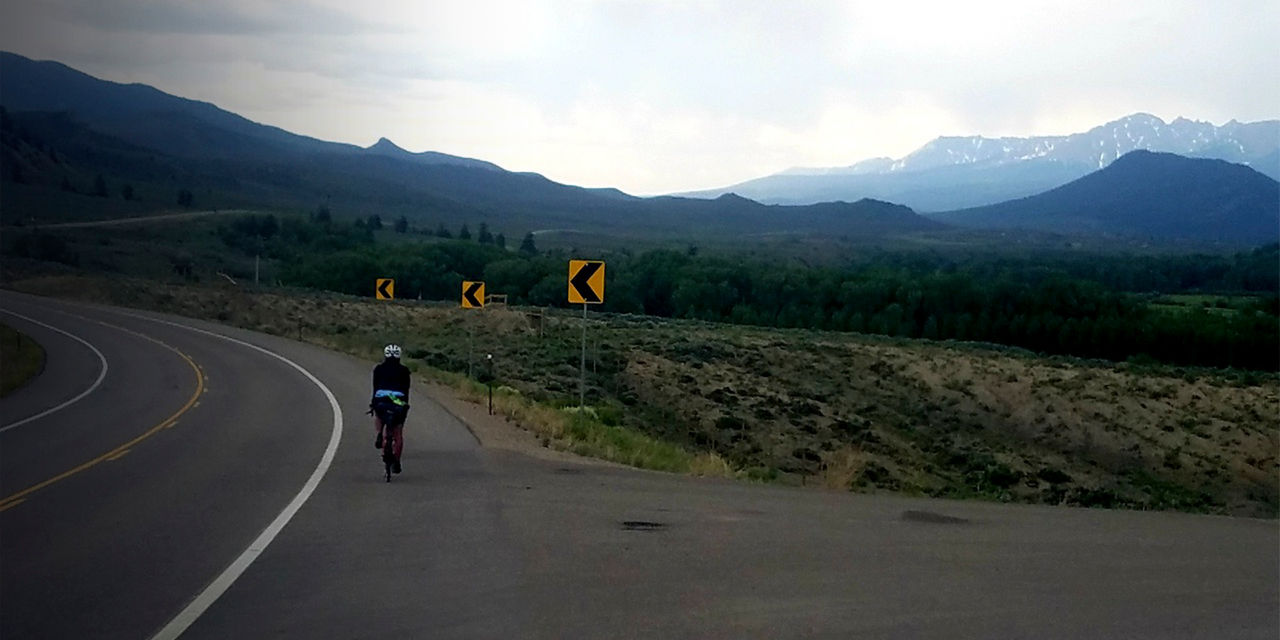 Brooke Barney rides her bike on a road
