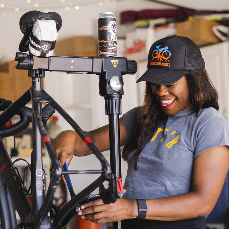 Brooke Goudy smiles as she fixes a part on her bike 