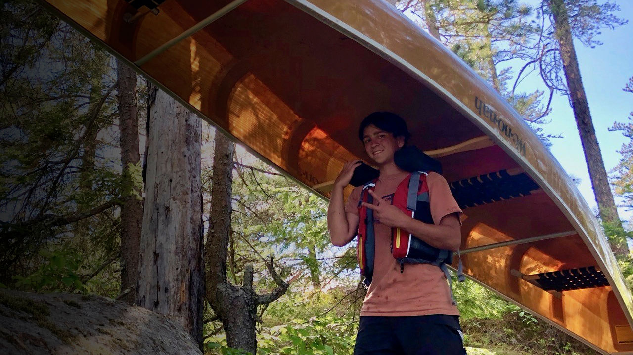 Joseph Goldstein walks with a canoe in the Boundary waters