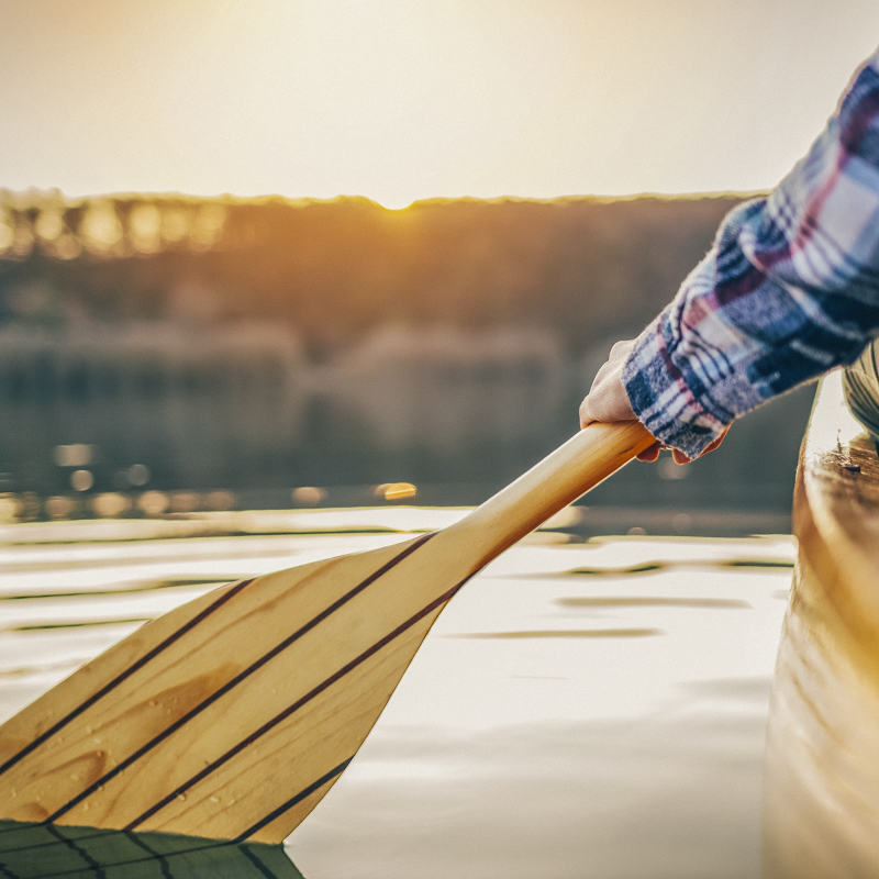 A close up of a canoe paddle in the water
