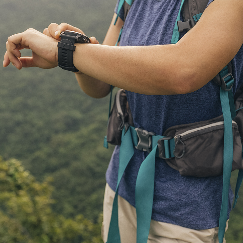 A woman checks her GPS watch during a backcountry trip