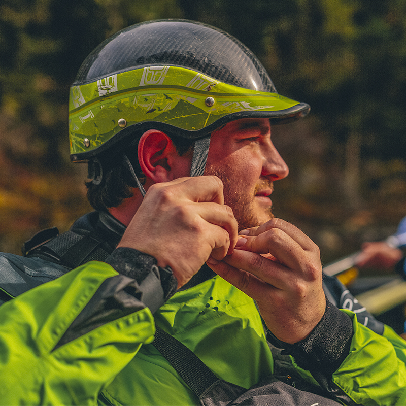 A man in a drysuit puts on a helmet before going whitewater rafting on the Lochsa River in Idaho. 