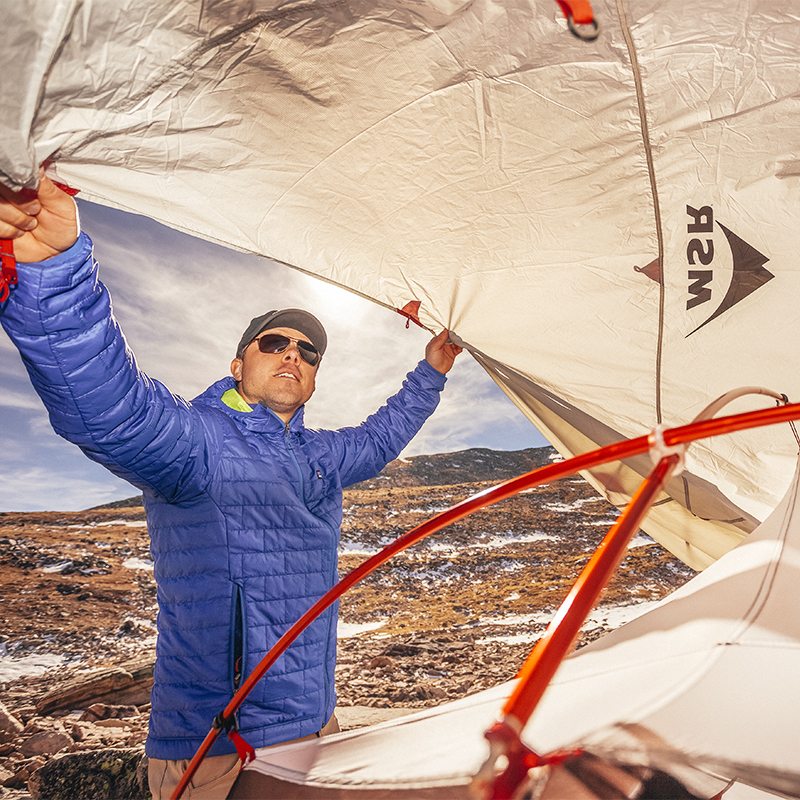 A man sets up his tent in the winter
