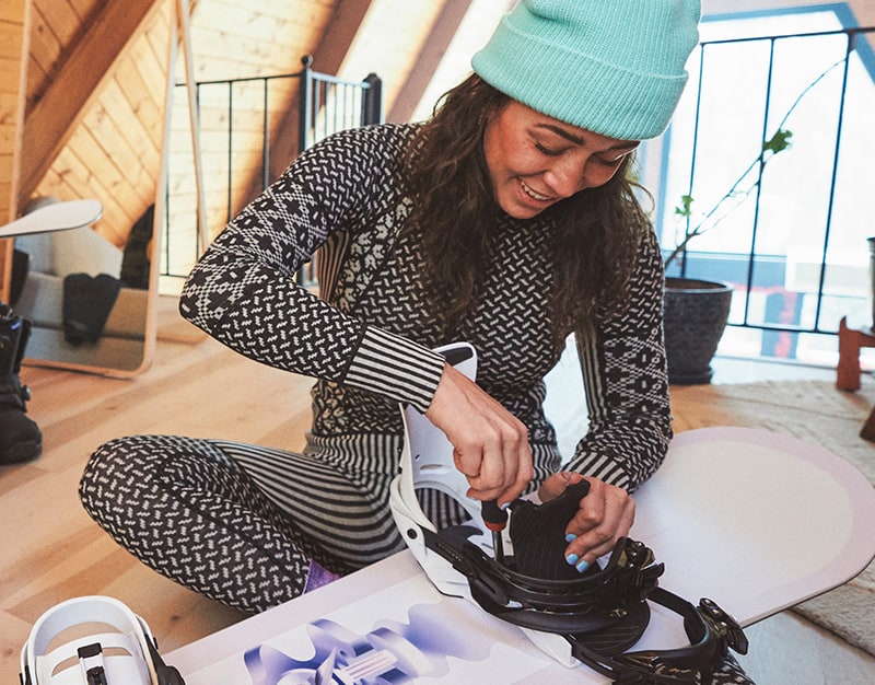 Female Snowboarder wearing a jacket, base layer, goggles and helmet in the snow