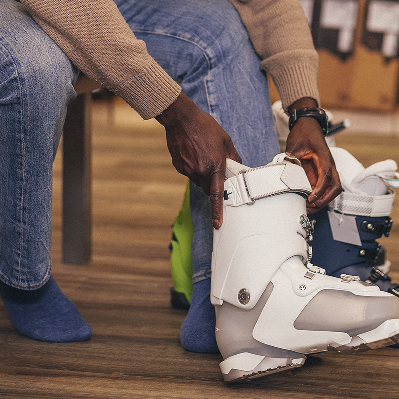 A man putting on a ski boot