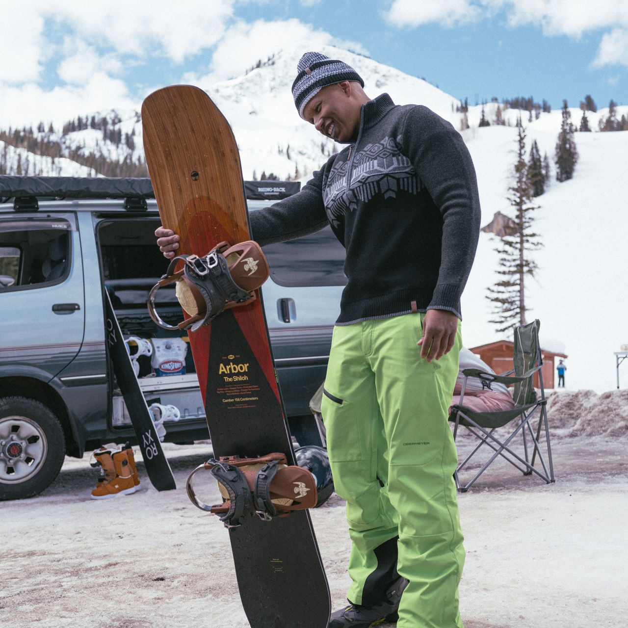 A man looks at his snowboard bindings