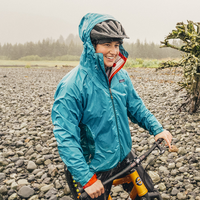 A woman smiles in the rain on her bike in the Kenai Fjords National Park.