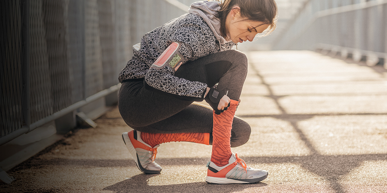 Pretty Caucasian sportswoman preparing for running.