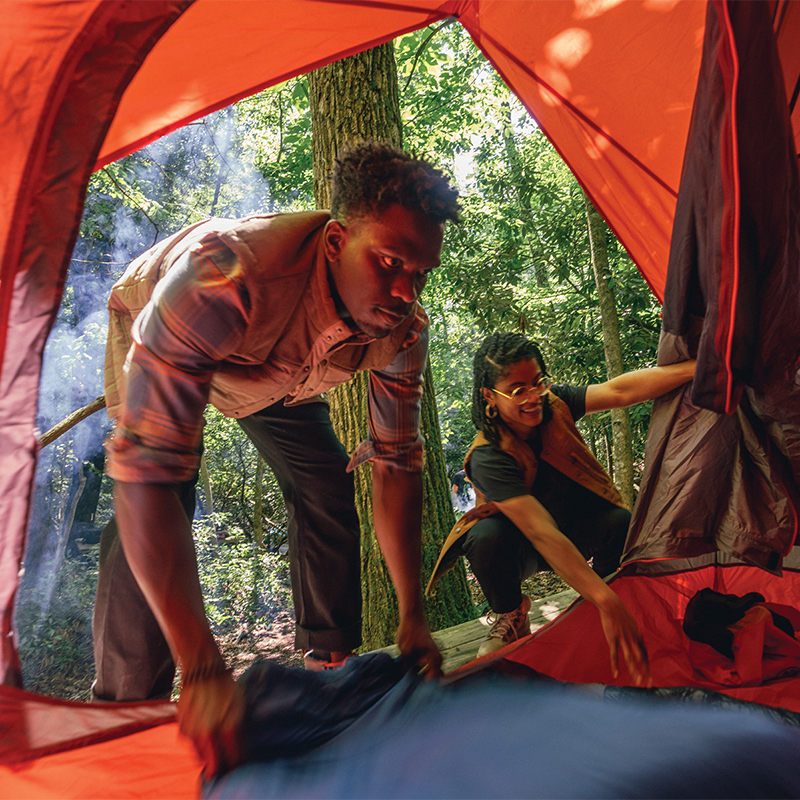 Two campers prepping their tent