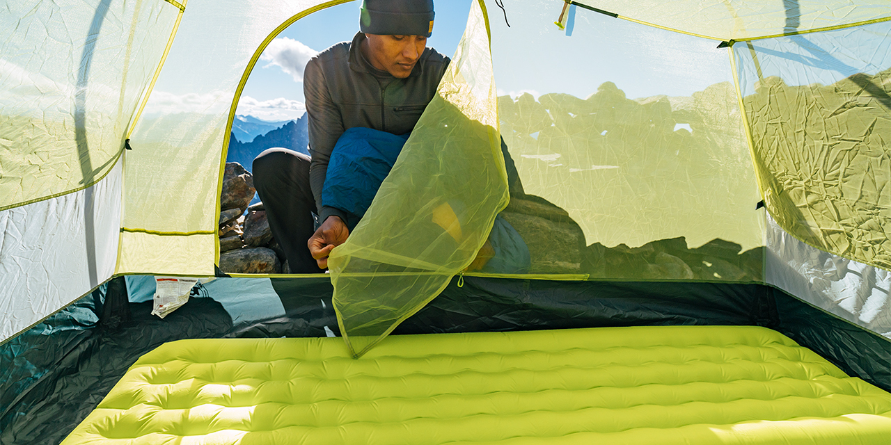 A hispanic hiker sets up his sleeping arrangements at the Sahale Glacier Camp in North Cascades National Park, Washington.