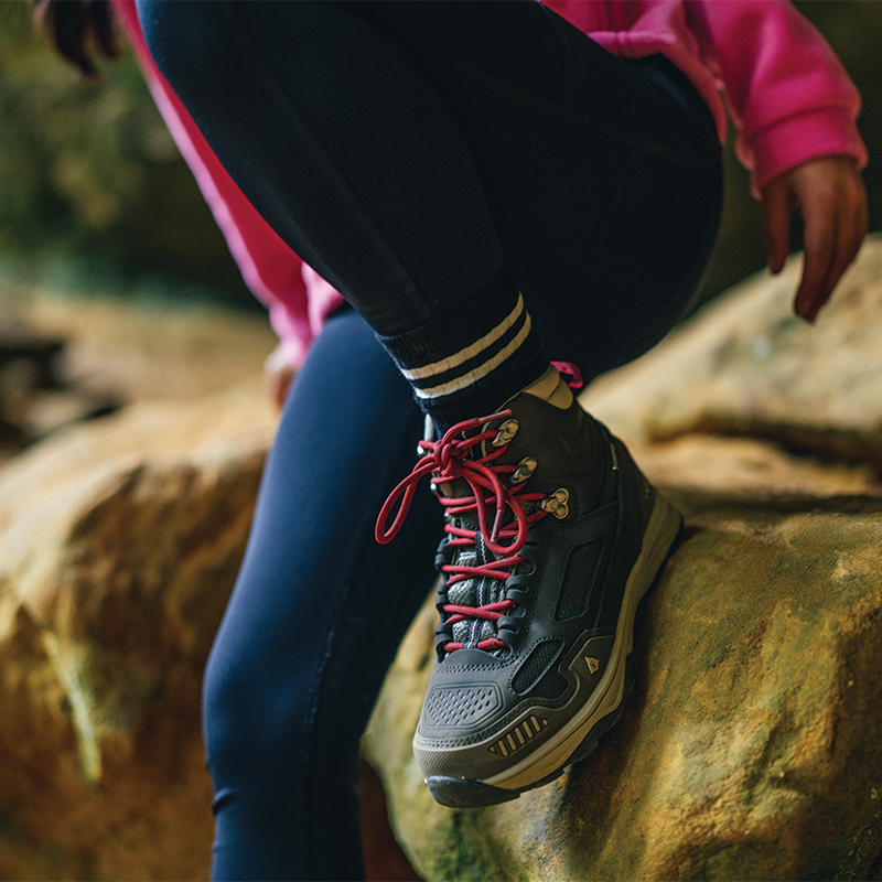 Close up on shoes of someone sitting on a rock