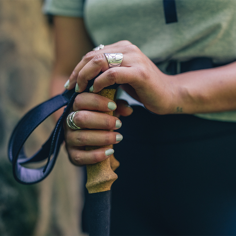 A woman holding a trekking pole with both hands