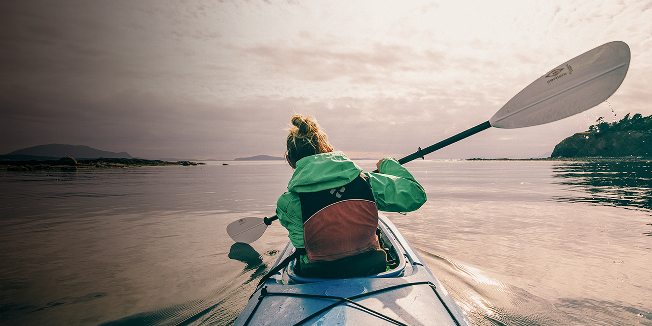 A woman paddles through the Salish Sea near Sucia Island State Park in the San Juans.