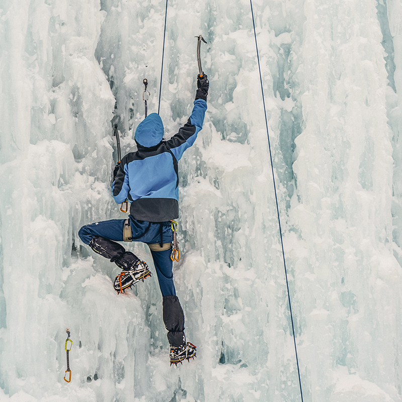 climber climbing a frozen waterfall