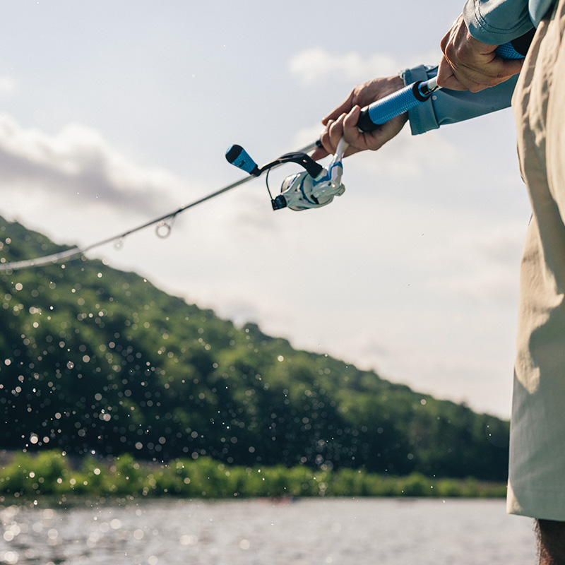 a man fly fishing, close up on fishing rod