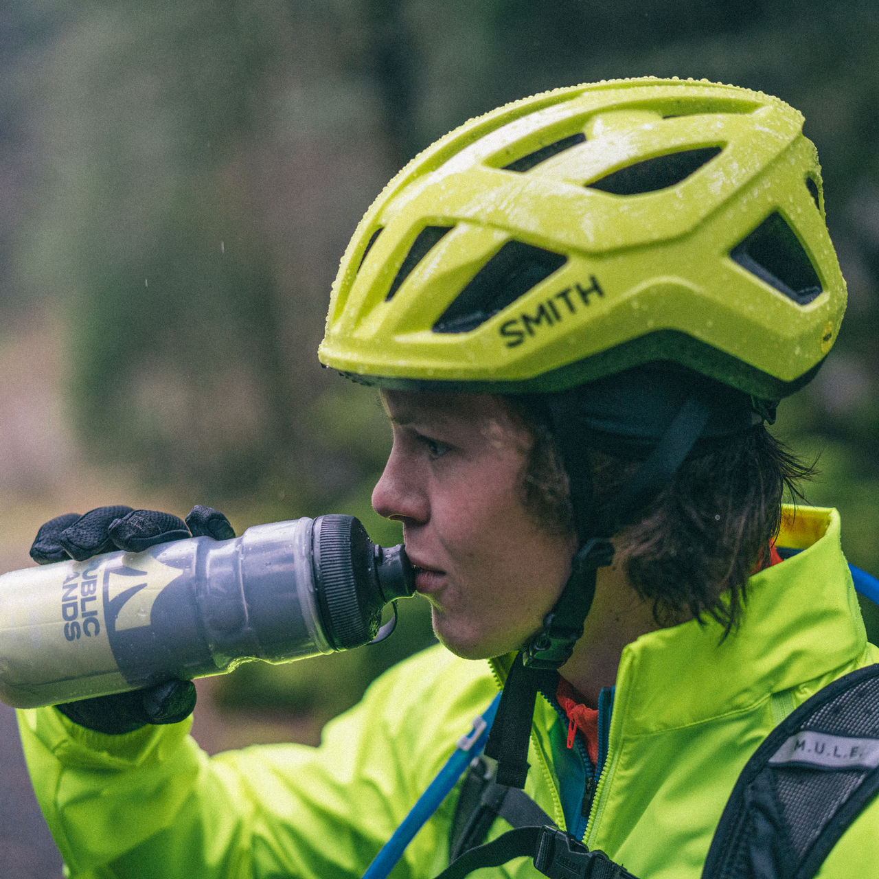 A biker drinking from a water bottle